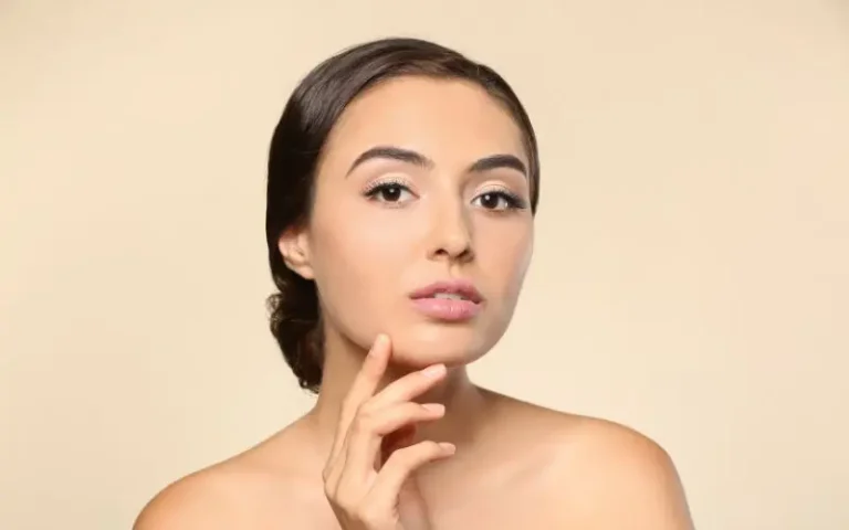 Woman touching smooth jawline after Kybella Missoula double chin treatment at Bellamah Aesthetics